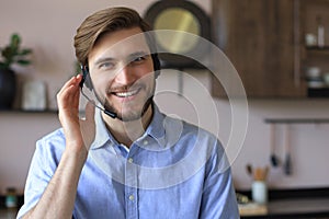 Confident man wearing headset speaking and watching business webinar training, listening to lecture