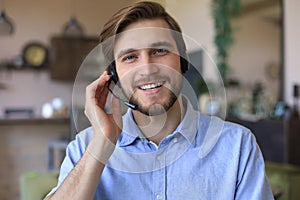 Confident man wearing headset speaking and watching business webinar training, listening to lecture