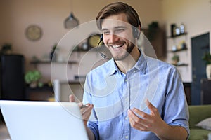 Confident man wearing headset speaking and watching business webinar training, listening to lecture