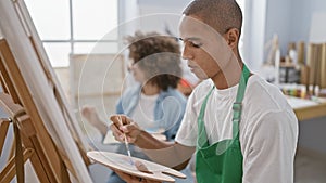 Confident man and woman artists joyfully drawing together at art class in cozy studio