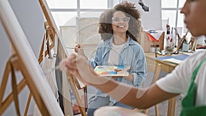 Confident man and woman artists joyfully drawing together at art class in cozy studio