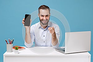 Confident man work at desk with pc laptop isolated on blue background. Achievement business career concept. Mock up copy