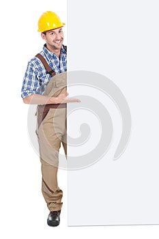 Confident manual worker holding billboard