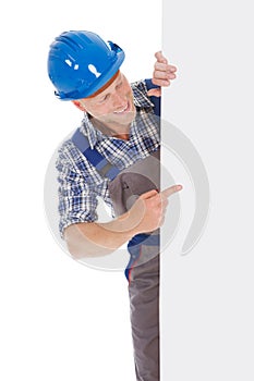 Confident manual worker holding billboard