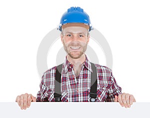 Confident manual worker holding billboard