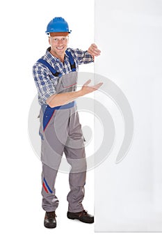 Confident Manual Worker Holding Billboard