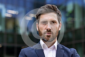 Confident mature businessman in suit posing in urban environment