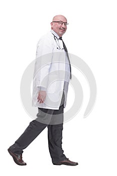 confident mature doctor in a white coat striding forward .