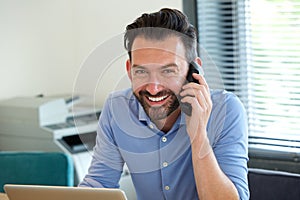 Confident mature guy talking on mobile phone and smiling