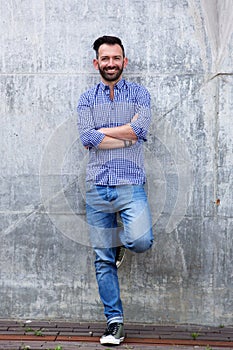 Confident mature man standing against wall