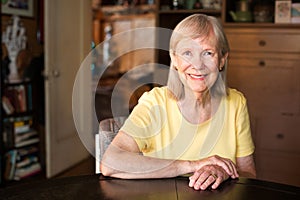 Confident mature woman seated at table