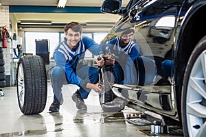 Confident Mechanic Changing Car Tire In Garage