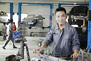 Confident Mechanic Fixing Car Engine, Looking At Camera