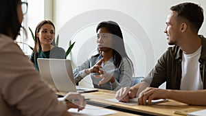 Confident millennial mixed race woman leader giving instructions to team