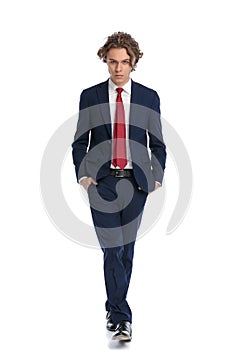 Confident modern guy in suit posing with hands in pockets