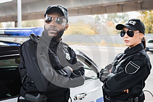 Confident multicultural police officers with crossed