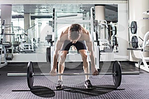 Confident muscular man training squats with barbells over head. Closeup portrait of professional man workout with barbell at gym.