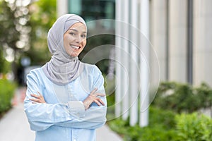 Confident Muslim woman smiling outdoors in urban setting