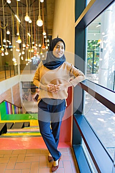 Confident muslim woman standing in a shopping mall with shadow effects