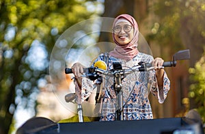 Confident Muslim woman using cargo bike in urban area