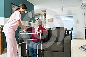 Caregiver Supporting Elderly Disabled Patient At Home photo