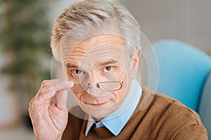 Confident old man wearing glasses looking into the camera