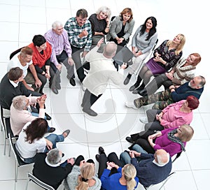 confident older man standing in a circle of like-minded people