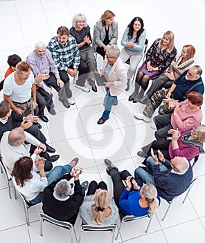 confident older woman standing in a circle of like-minded people