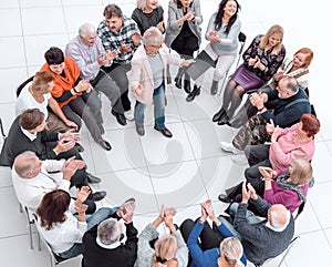 confident older woman standing in a circle of like-minded people