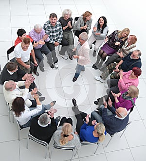 confident older woman standing in a circle of like-minded people
