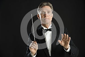 Confident Orchestra Conductor Directing With His Baton photo