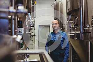 Confident owner standing amidst manufacturing equipment