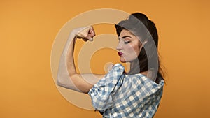 Confident pin up woman showing biceps and winking with smile