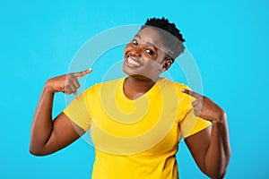 Confident Plus-Size Black Woman Pointing Fingers At Herself, Blue Background