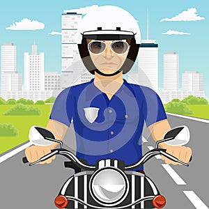 Confident policeman with sunglasses riding motorcycle through the city streets