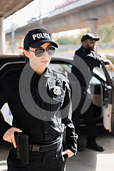 Confident policewoman with hand on gun