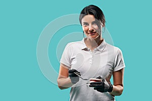 Confident portrait of female doctor dentist in medical uniform with dental tools and jaw cast posing looking at the camera on blue