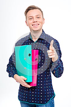 Confident positive man holding colorful folders and pointing on you