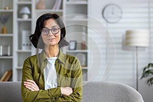 Confident professional woman standing in modern living room interior