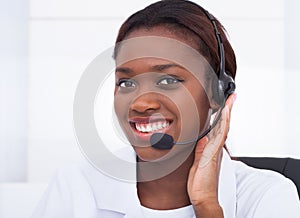 Confident receptionist using headset in hospital