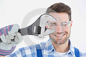 Confident repairman wearing protective glasses while holding wrench