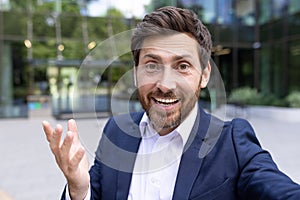 Confident senior businessman chatting in front of modern office building, corporate professional