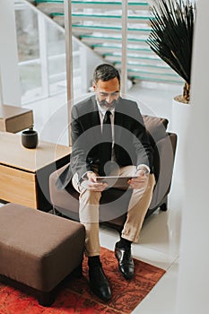 Confident senior businessman with digital tablet