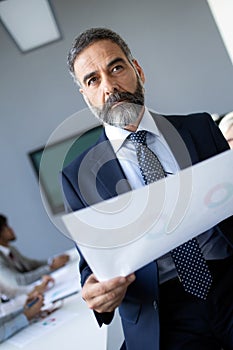 Confident senior businessman leader working in office