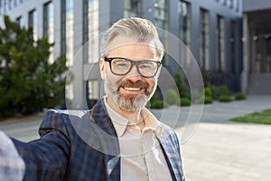 Confident senior businessman smiling in suit outside corporate building