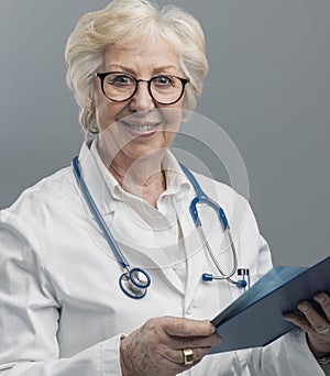 Confident senior female doctor posing and smiling