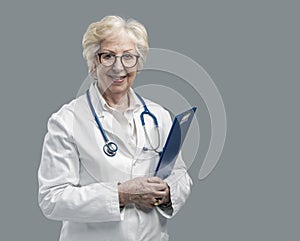 Confident senior female doctor posing and smiling