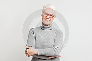 Confident senior woman posing with arms crossed photo