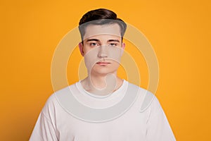 Confident serious young male enterpreneur isolated over yellow background