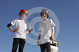 Confident Skateboarders Standing Against Blue Sky